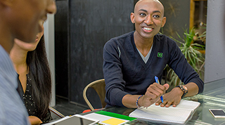 A TD colleague smiles while participating in a group meeting.
